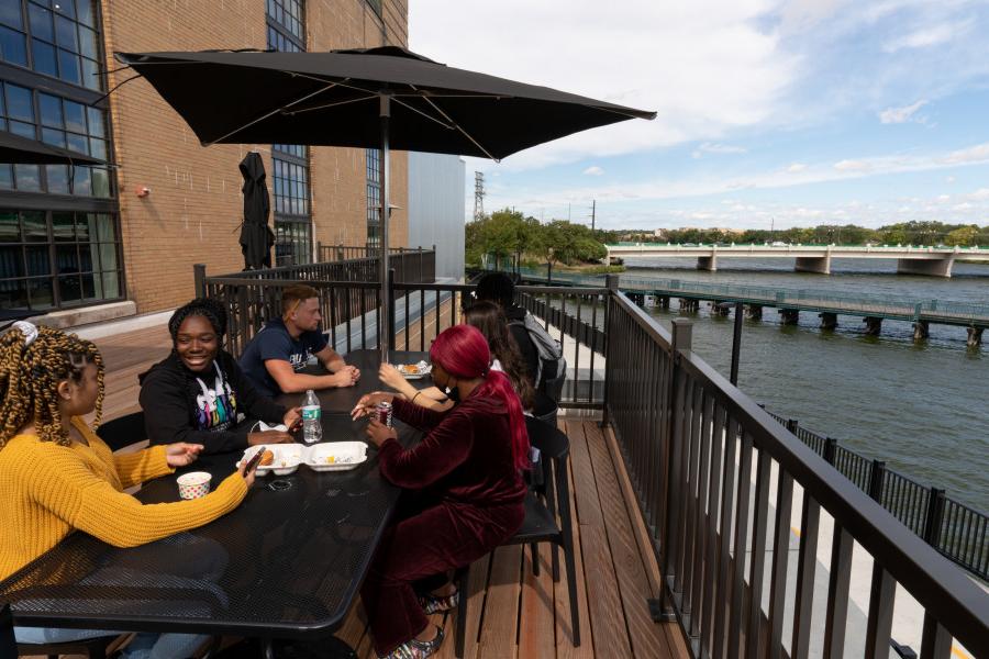 Students eating on the Powerhouse's terrace alongside the Rock River