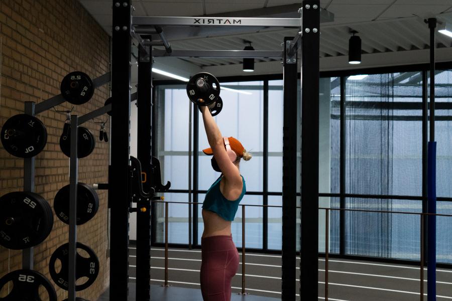 Student lifting weights on the fitness floor of the Powerhouse.