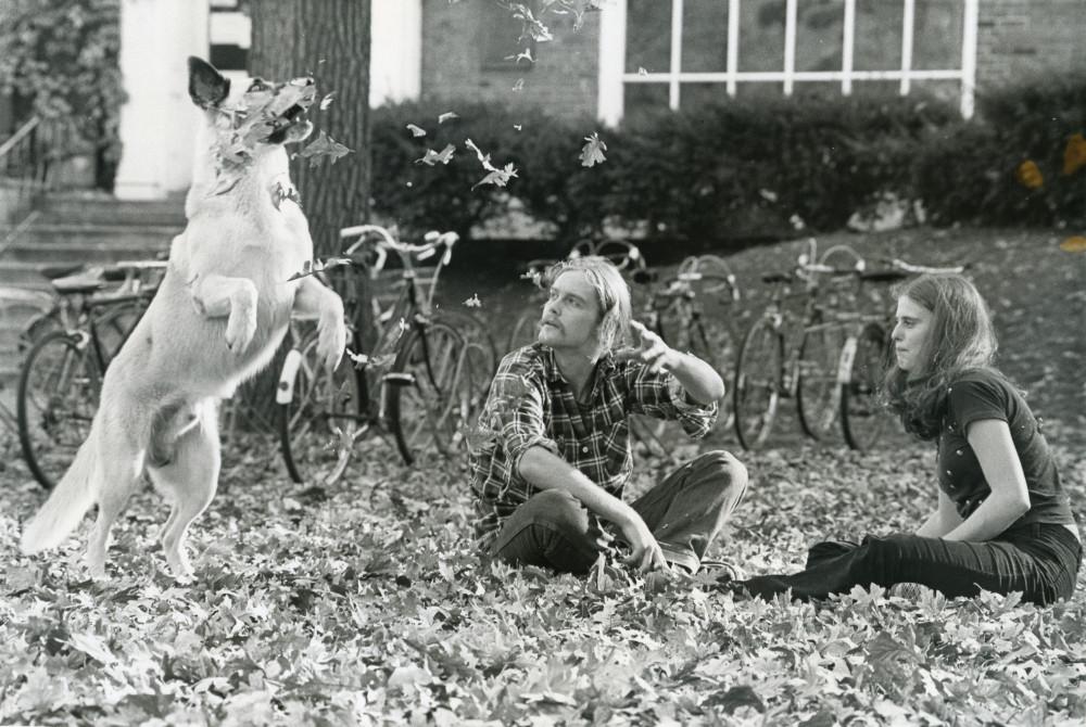 Two students and a dog pictured in front of the Student Union in the fall of 1976.