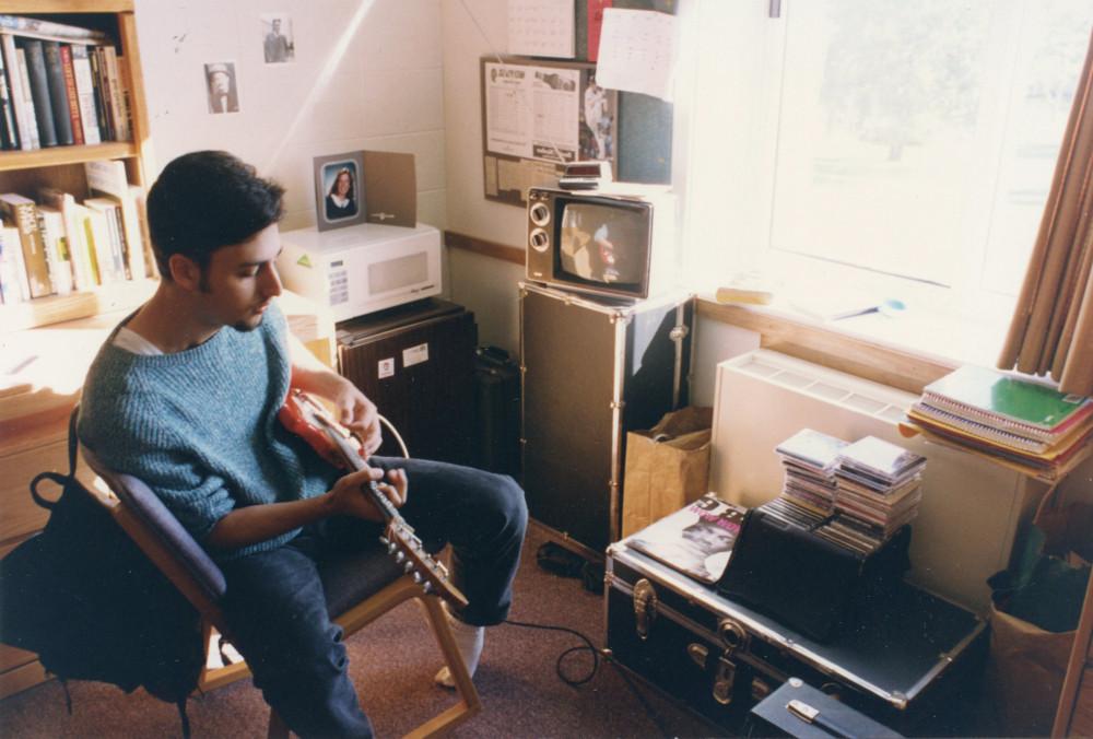 A student plays guitar in their dorm room in 1993.